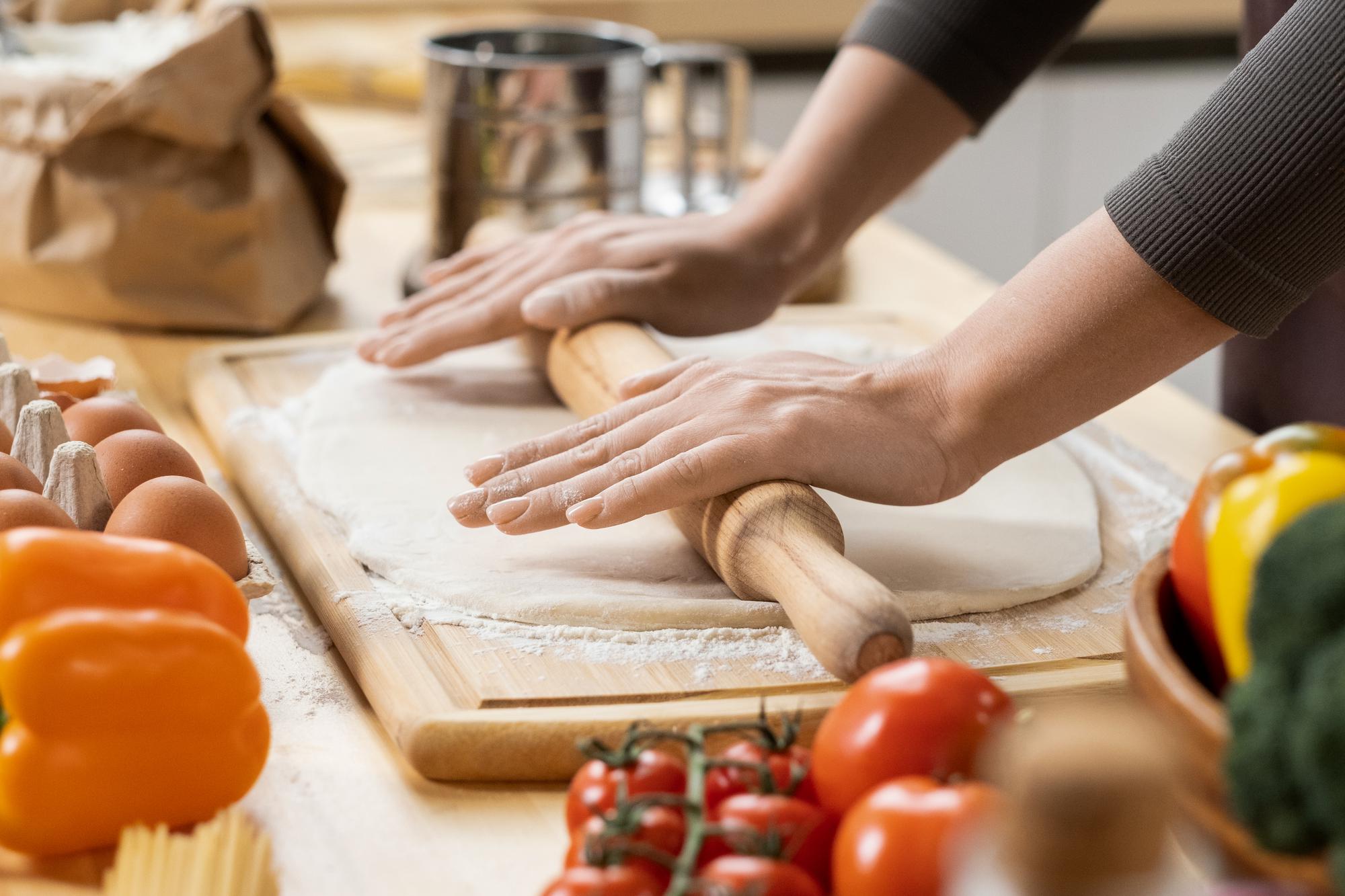 Workshop table with ingredients and hands preparing dough